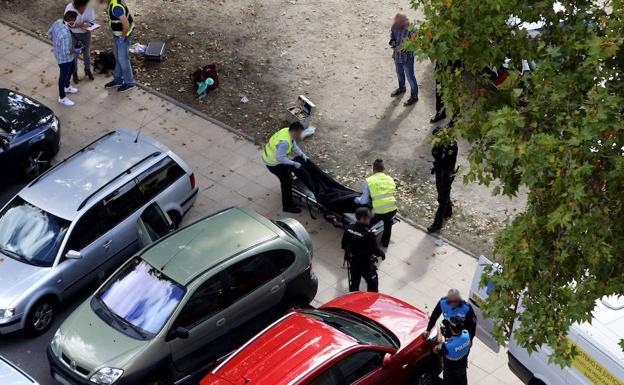 Funcionarios trasladan el cuerpo sin vida de Ana Belén Jiménez, arriba a la derecha, en presencia de la Policía local. 