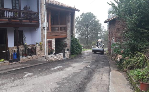 Un operario se encarga de rebachear y hormigonar varias carreteras y caminos de esta parroquia de Villaviciosa.