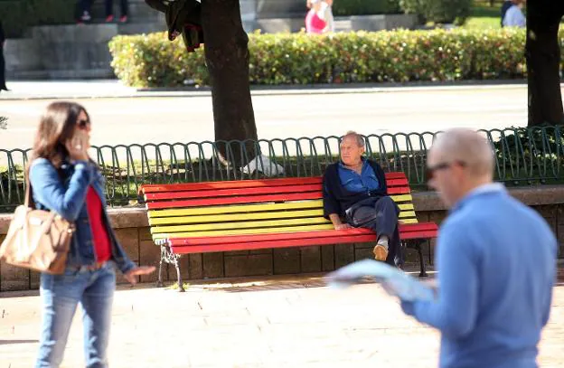 Un hombre sentado en uno de los bancos de la Escandalera que han cambio de color. 