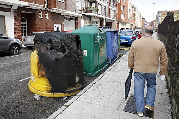 Contenedor de reciclaje de plástico quemado en la calle Bélgica, en Contrueces. 