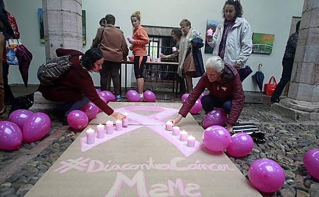 Velas rosas encendidas para conmemorar el Día contra el Cáncer de Mama en Grado.