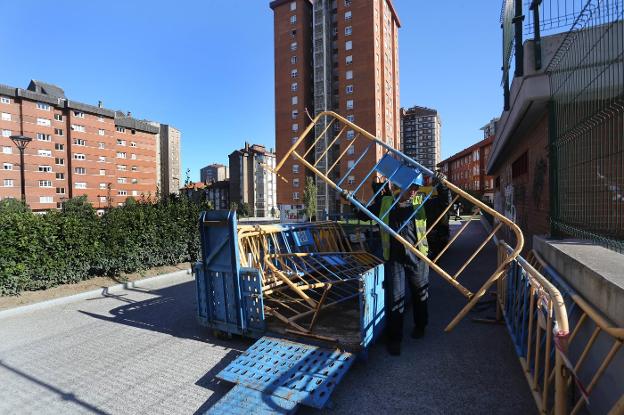 Un operario, ayer, colocando vallas en la plaza del Polígono que hay que levantar en parte. 