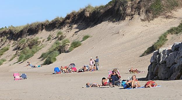 Imagen de bañistas tomando el sol junto a las dunas de la playa de San Juan tomada el pasado día 24 de octubre. 