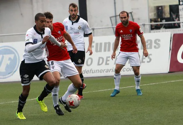 Thaylor, del Caudal, conduce el balón, presionado por un rival. 