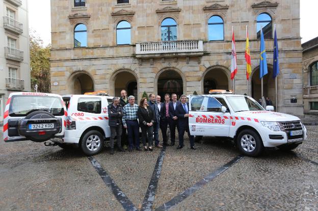 Representantes de los grupos municipales y el jefe de bomberos, con los nuevos vehículos en la Plaza Mayor. 