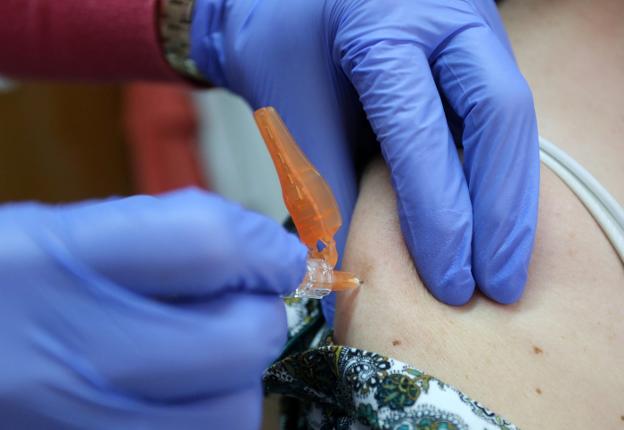 La enfermera inocula la vacuna antigripal en el centro de salud de Laviada. 