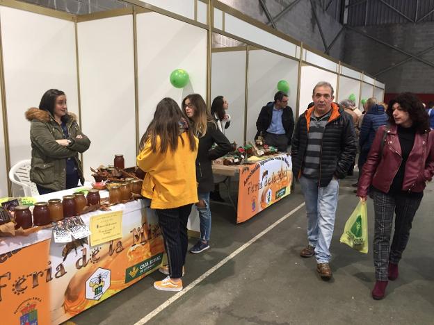 Un hombre y una mujer recorren los puestos de la feria.
