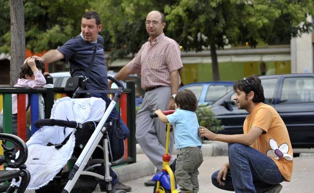 Padres juegan con sus hijos en un parque.