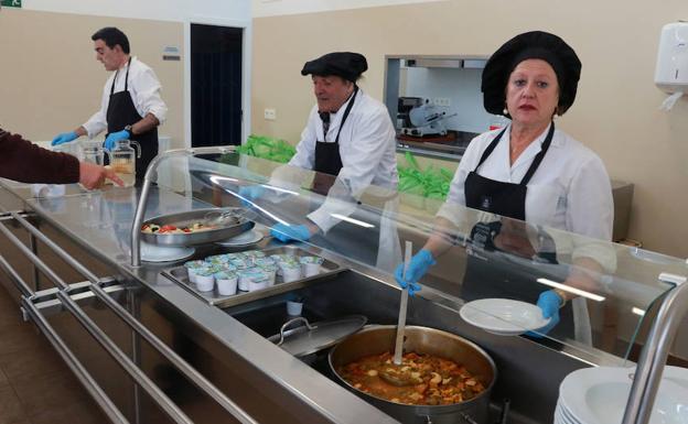 Arsenio Iglesias, Félix Montes y Pilar Crespo, sirven la comida en el comedor de Amicos.