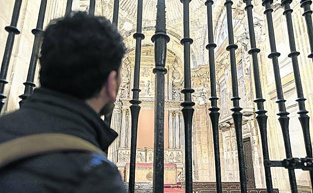 Un visitante de la Catedral observa la Capilla de los Vigiles tras la reja. 