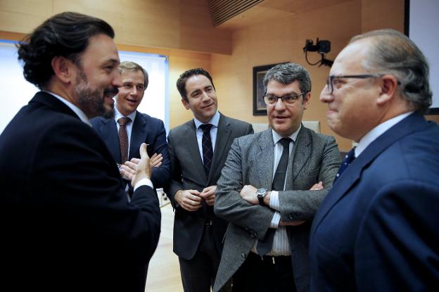 El ministro Álvaro Nadal (segundo por la derecha) charla con varios diputados a su llegada al Congreso. 