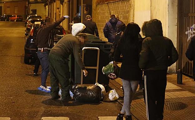 Agentes revisan los contenedores cercanos en busca del arma homicida.