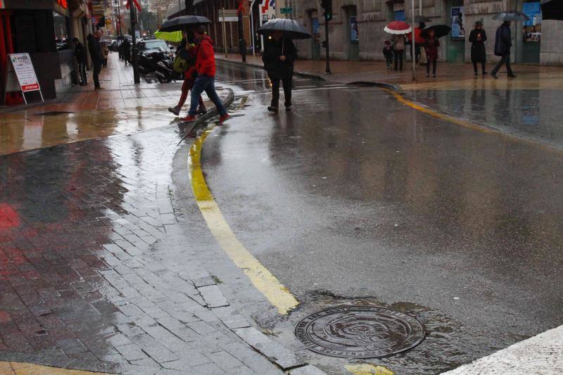 Turistas por Asturias bajo la lluvia