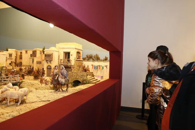 Una niña contempla 'El belén de los tintoreros' en el Antiguo Instituto. 