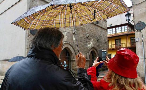 Dos turistas fotografían el palacio de Valdecarzana durante su recorrido por el centro de la ciudad ayer. 