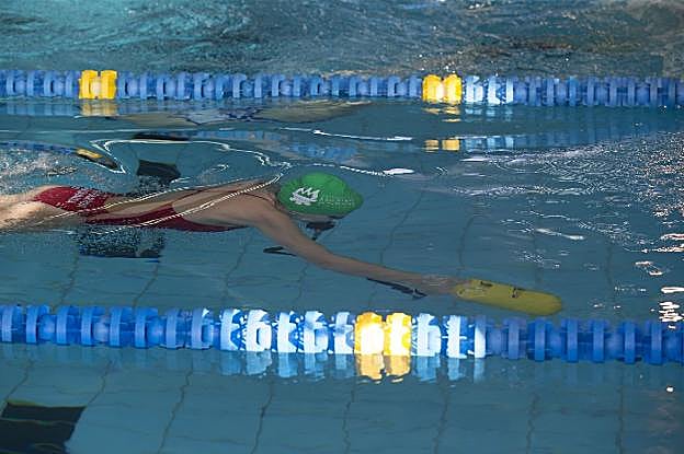 Una usuaria nada por una de las calles de la piscina municipal de El Llano. 