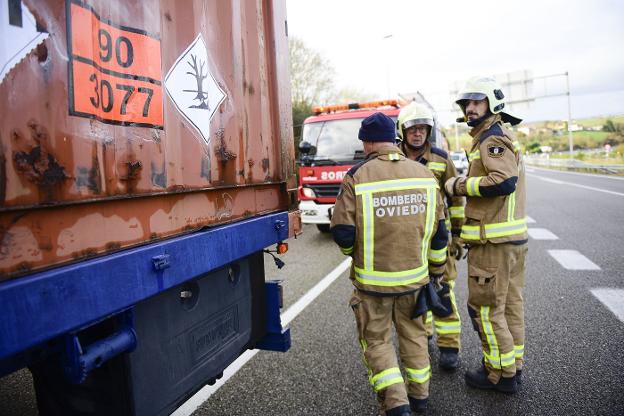 Los efectivos de bomberos junto al camión averiado en el arcén de la A-63. 