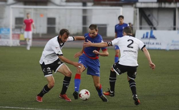 Adrián Llano e Invernón trata de frenar a un jugador del Amorebieta.