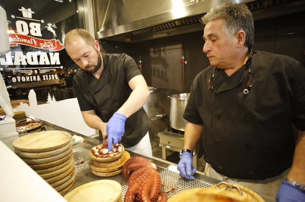 Dos cocineros preparan un plato de pulpo en el restaurante Tierras Gallegas, de Gijón. 