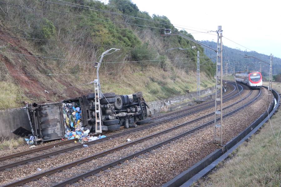 Un camión de basura vuelca a las vías del tren en Llanera