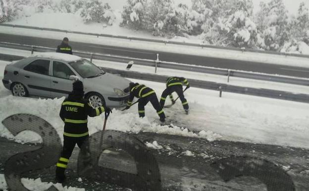 Soldados de la Unidad Militar de Emergencias retiran con palas la nieve a la altura de Villacastín. 