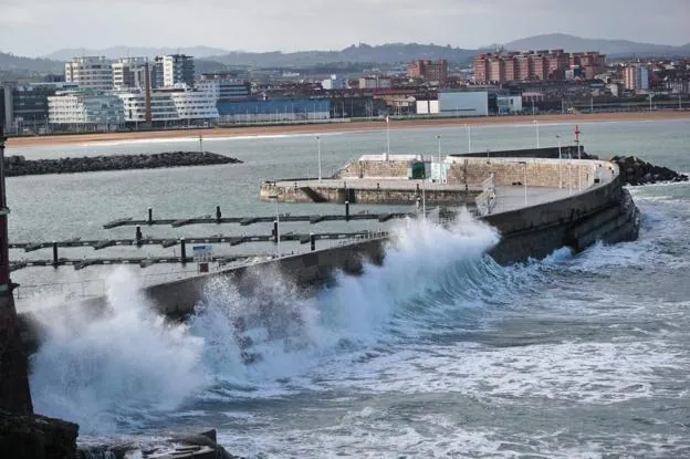 Las olas rompen contra el espigón de Lequerique, en Gijón. 