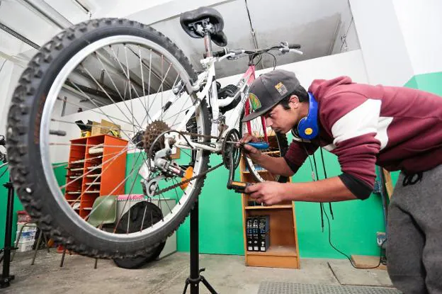 Daniel Jiménez comprueba la cadena de una bicicleta en 'BiciLab'. 