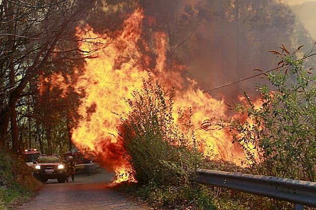 Efectivos llegando al frente de un incendio que quemó parte de Olloniego en marzo pasado.