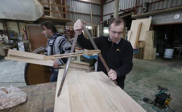 José Argüelles marca con un compás el contorno de la cabeza o tapa del tonel. La madera de castaño es la más usada por los toneleros de Breceña.