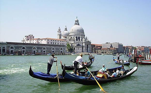 Turistas pasean en góndola por los canales de Venecia