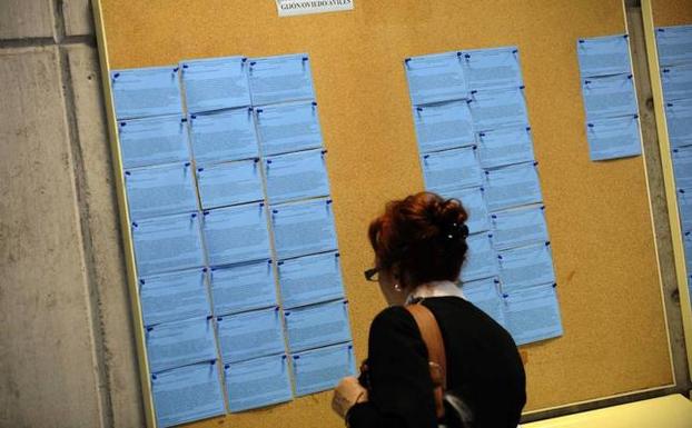 Una mujer revisa el tablón de ofertas de trabajo en una oficina de empleo de Gijón