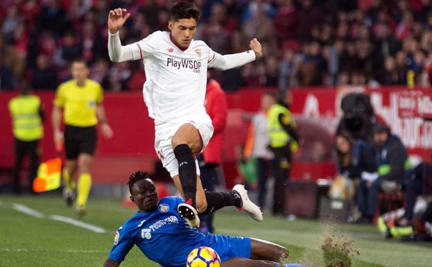 Djené y Correa disputan un balón.