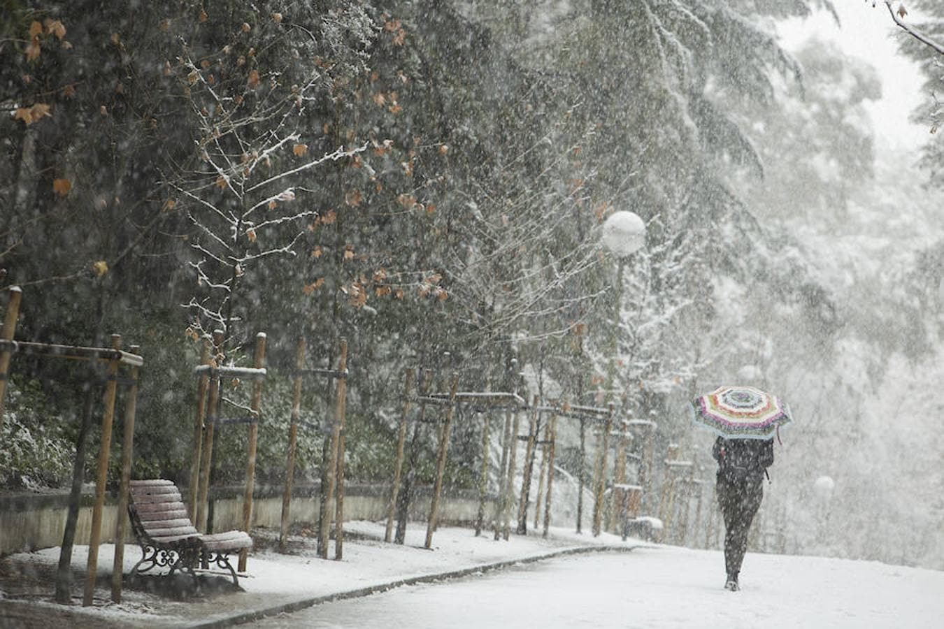 Una joven se proteje de la intensa nevada con su paraguas.