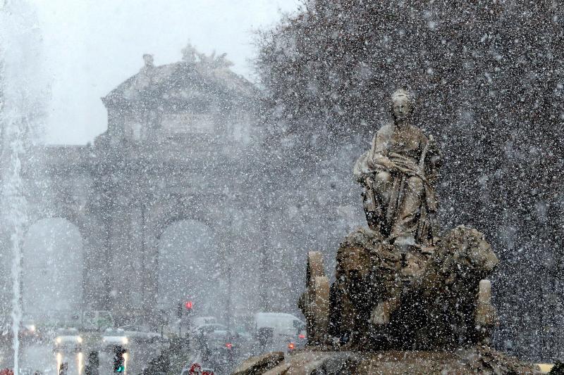 Vista de la fuente de Cibeles bajo la intensa nevada caída esta mañana en el centro de la capital.