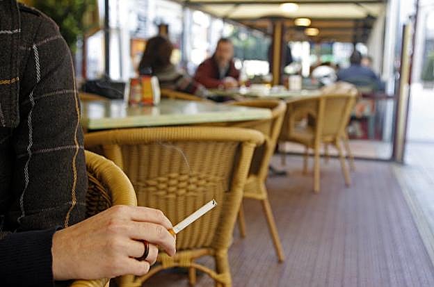 Una mujer fuma en la terraza de un bar en Oviedo 