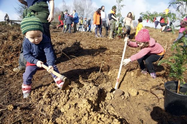 Dos niños participando ayer en la plantación. 