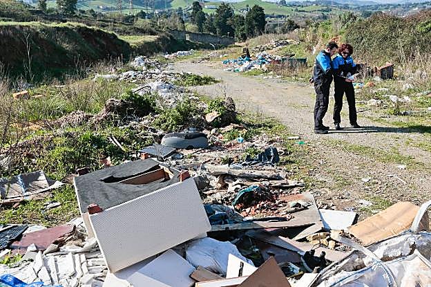 Agentes de la Unidad de Vigilancia Ambiental supervisan un vertedero ilegal en el barrio de Perchera-La Braña. 