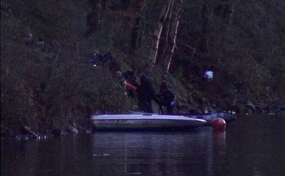 Momento en que la Guardia Civil alza la camilla con los restos mortales de la gijonesa por la ladera del embalse de Arbón, en el concejo de Villayón. 