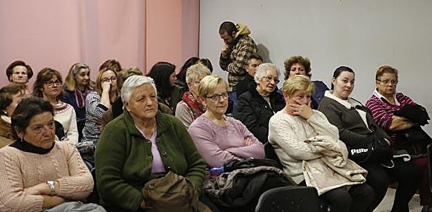 Vecinos del poblado minero de La Camocha en riesgo de deshaucio, durante la reunión en la biblioteca donde se les informó de la situación. 