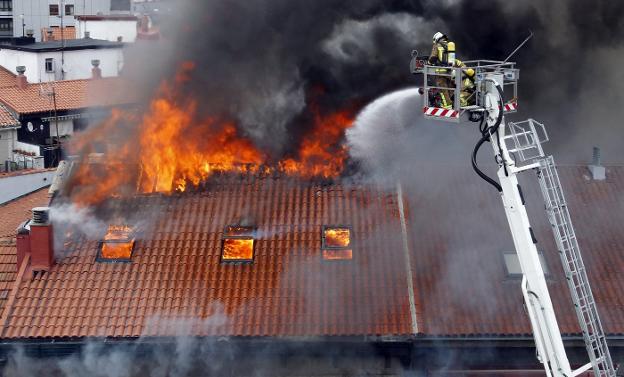 Los dos bomberos, en la cesta durante el incendio de Uría el 7 de abril de 2016. 