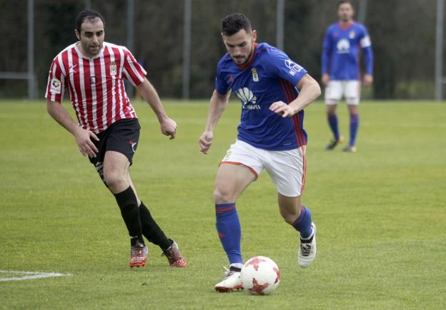 El oviedista Lobato conduce el balón ante Abraham. 