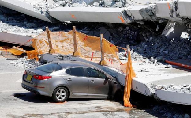 Un vehículo, aplastado por el puente.