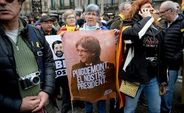 Una mujer muestra un cartel en apoyo a Puigdemont en Barcelona. 