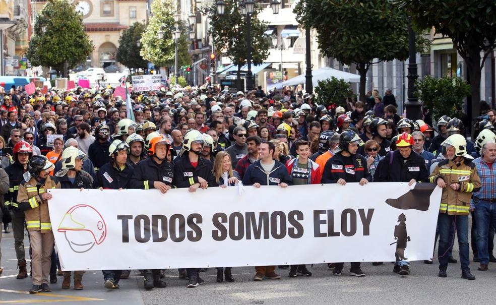 La cabecera de la manifestación con Marta Valle, Luis y David Palacio, viuda e hijos de Eloy Palacio, acompañados por 'Cuni' y varios bomberos con la pancarta de apoyo. 