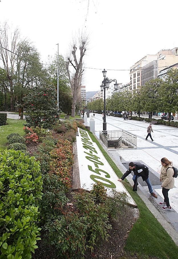 Una pareja, ayer, ante el calendario en el paseo de los Álamos. 