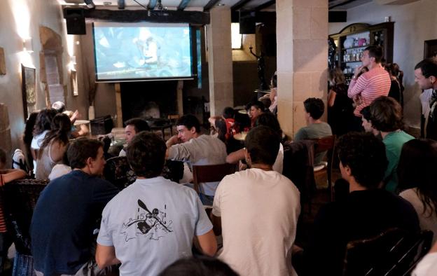 Clientes de un bar miran la televisión. 