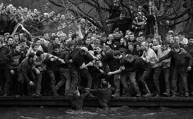 Imagen. La foto muestra a los miembros de equipos contrarios, los Up'ards y Down'ards, luchando por el balón durante el histórico y anual partido de fútbol Royal Shrovetide en Ashbourne, Derbyshire (Reino Unido), el 28 de febrero de 2017.