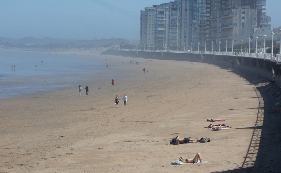 Primeros baños de sol en la playa de Salinas propiciados por temperaturas casi veraniegas. 