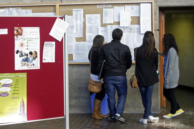 Un grupo de alumnos consulta unas notas en el tablón de una facultad de la Universidad de Oviedo. 