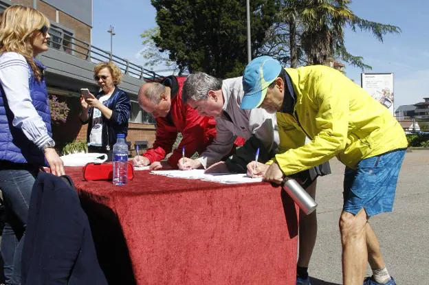 Grupistas firmando a favor de que el grado de Deportes se implante en Gijón. 